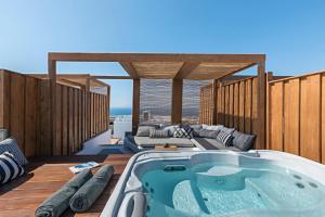 bañera de hidromasaje en la cubierta de una casa en 3 Elements by Stylish Stays, en Oia