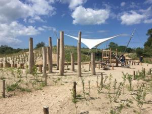 um parque infantil na areia com uma rede branca em vakantiehuisje 007 em Koksijde