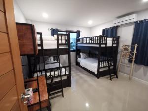 um quarto com três beliches num quarto em DAAD FAH home and cafe em Phetchaburi