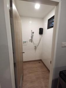 een badkamer met een douche en een slang aan de muur bij DAAD FAH home and cafe in Phetchaburi