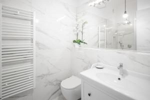 a white bathroom with a toilet and a sink at AB Ljubljana - Prince Filip Apartment in Ljubljana