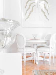een witte eetkamer met witte stoelen en een tafel bij AB Ljubljana - Prince Filip Apartment in Ljubljana
