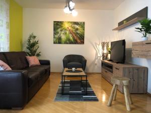 ein Wohnzimmer mit einem Sofa und einem TV in der Unterkunft Apartma Kreda in Mojstrana