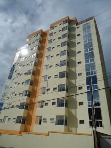 un edificio alto con el sol brillando en él en Spot Residence São Carlos 700m da USP en São Carlos
