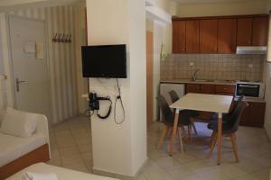 a room with a kitchen and a table with a television at Aliki Studios in Parga