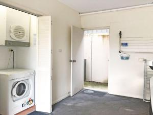 a laundry room with a washing machine and a door at Dutchies Vista, 1 45 Christmas Bush Ave - Ground floor duplex with stunning water views and close to the beach in Nelson Bay