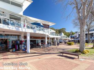 un edificio con un banco delante de él en Dutchies Haven, 11 Christmas Bush Ave - Pet friendly, large enclosed yard, air con and Wi-Fi en Nelson Bay