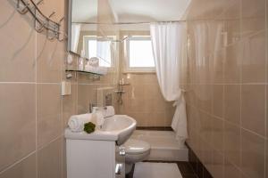 a bathroom with a sink and a toilet and a window at Apartments Center Opatija Ziric in Opatija
