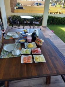 a wooden table with plates of food on it at Pousada Vila dos Santos in Porto De Galinhas