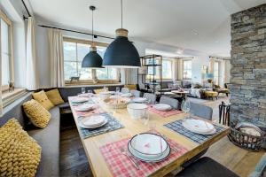 a living room with a table with plates and wine glasses at Königshaus by Alpin Bookings in Mühlbach am Hochkönig