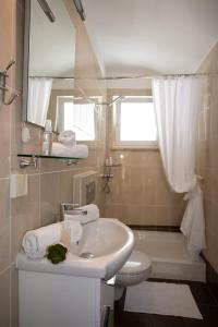 a bathroom with a sink and a toilet and a mirror at Apartments Center Opatija Ziric in Opatija