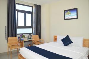 a bedroom with a bed and a desk and a window at Lucky Star Ho Tram Hotel & Restaurant in Ho Tram +40 photos