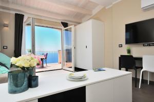 a kitchen and living room with a view of the ocean at Amalfi Blu Retreat in Amalfi