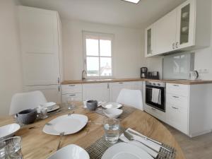 a kitchen with a wooden table and white cabinets at Haus Elve in Zierow