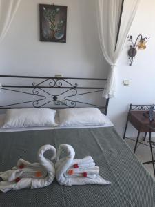 twee zwanen handdoeken op een bed in een slaapkamer bij Anastasia Studios, Apartments & Suites in Archangelos