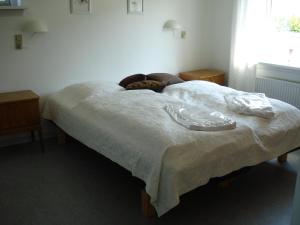 a bedroom with a bed with a white comforter at Djurs-BnB - Rimsøhuset in Rimsø