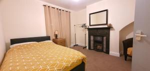 a bedroom with a bed with a fireplace and a mirror at Grace Apartments - Living Waters 1 in Ashford
