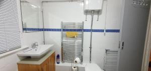 ein weißes Bad mit einem Waschbecken und einer Dusche in der Unterkunft Grace Apartments - Living Waters 1 in Ashford