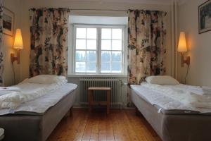 two beds in a room with a window at Öster Malma vandrarhem in Nyköping