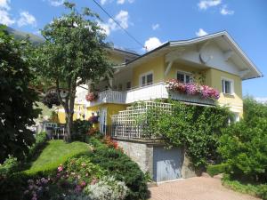 ein gelbes Haus mit Blumen auf den Balkonen in der Unterkunft Ferienwohnung Kerschbaumer in Rangersdorf