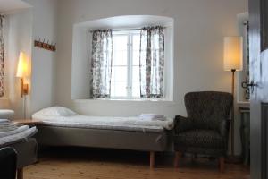 a bedroom with a bed and a chair and a window at Östermalma vandrarhem in Nyköping