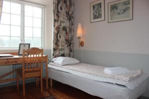 Habitación pequeña con escritorio y cama con ordenador. en Östermalma vandrarhem, en Nyköping