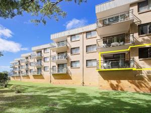 um edifício de apartamentos com um relvado em frente em Intrepid 1 3 Intrepid Close Amazing views of Shoal Bay only 100m from the Beach em Shoal Bay