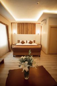 1 dormitorio con 1 cama y un jarrón de flores sobre una mesa en Line Suite Hotel, en Kırklareli