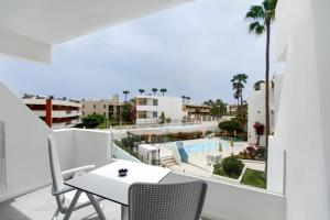 balcón con mesa, sillas y vistas a la piscina en Alsol Guatiza, en Playa del Inglés