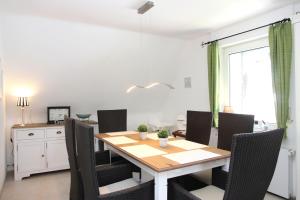 uma sala de jantar com uma mesa de madeira e cadeiras em Ferienwohnung Olsberg em Assinghausen