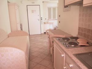 a kitchen with a stove and a table with chairs at Residence Panama in Alassio