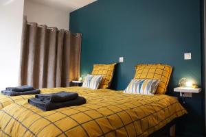 圖爾寬的住宿－Casa Blanc Seau，一间卧室设有黄色的床和蓝色的墙壁
