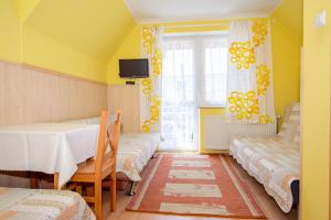 a room with four beds and a table and a window at Pokoje Gościnne Pod Gubałówką in Zakopane