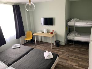 um quarto com 2 camas, uma secretária e beliches em Hotel Capitol Zentrum - 24h - em Friedrichshafen