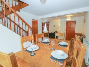 a dining room with a wooden table and chairs at Holly Tree Cottage in Coniston