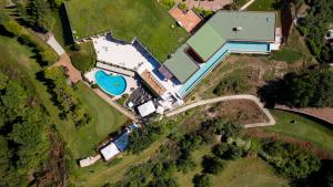 uma vista superior de uma casa com uma piscina numa colina em Golf Cà Degli Ulivi em Costermano