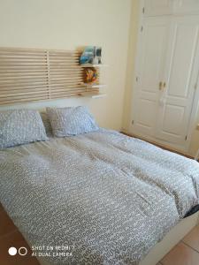 1 cama con edredón azul y almohadas en un dormitorio en Apartamento playa, en Islantilla