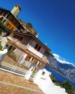 a house on top of a hill next to the water at La Madrugada in Malcesine