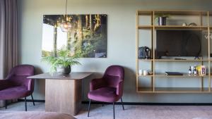 a room with two purple chairs and a table at Hotell Södra Berget in Sundsvall