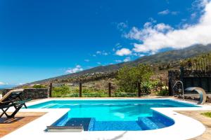 a swimming pool with a mountain in the background at La Capellana in Tijarafe