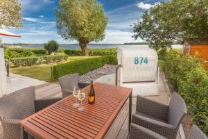 einen Holztisch mit Weingläsern auf einer Terrasse in der Unterkunft Fährhaus Sellin Haus am See in Ostseebad Sellin