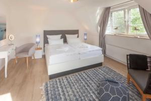 Schlafzimmer mit einem Bett, einem Schreibtisch und einem Stuhl in der Unterkunft Fährhaus Sellin Haus am See in Ostseebad Sellin