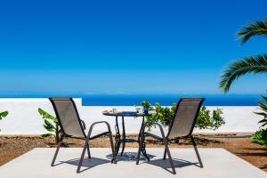 a table and two chairs and the ocean at La Capellana in Tijarafe