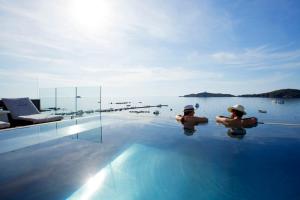 two people in the water in a swimming pool at Le Pinarello in Sainte-Lucie de Porto-Vecchio