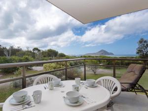 una mesa y sillas blancas con vistas al océano en Intrepid 13 fantastic unit with stunning water views, en Nelson Bay