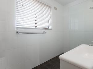 baño blanco con lavabo y ventana en Intrepid 13 fantastic unit with stunning water views, en Nelson Bay 14 fotos más