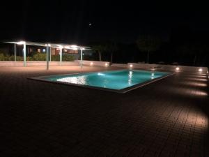 una piscina vuota di notte con luci di Terre Iblee Resort a Chiaramonte Gulfi