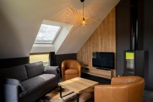 a living room with a couch and a tv at Refuge des 4 As in Durbuy