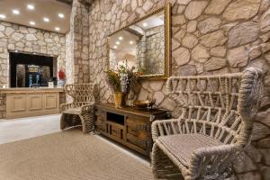 - une salle de bains aux murs de pierre avec 2 chaises et un miroir dans l'établissement Athens Manor Houses, à Athènes