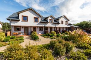 una casa con un jardín delante de ella en APARTAMENTY STARE SARBINOWO en Sarbinowo